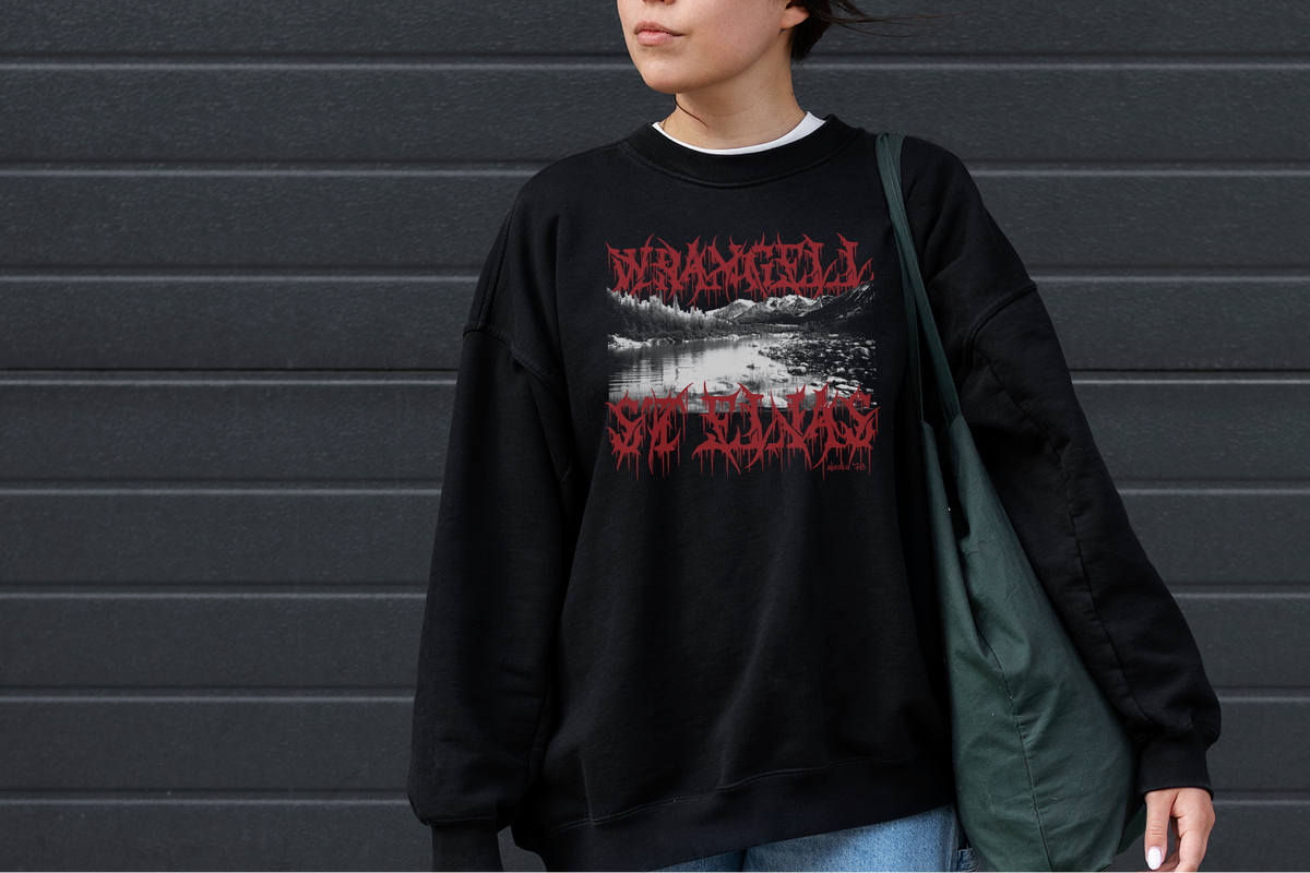 Person wearing a black sweatshirt with red and white text against a gray wall