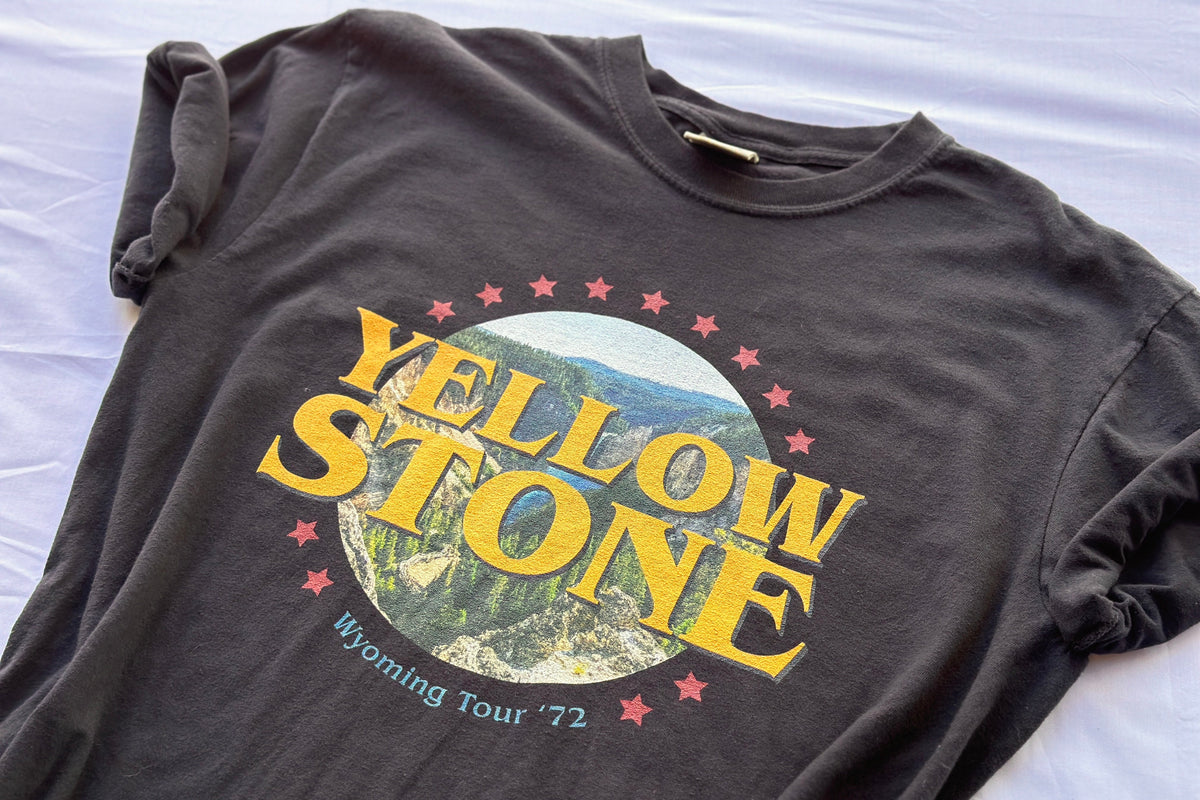 Black t-shirt with Yellowstone graphic design on a white surface