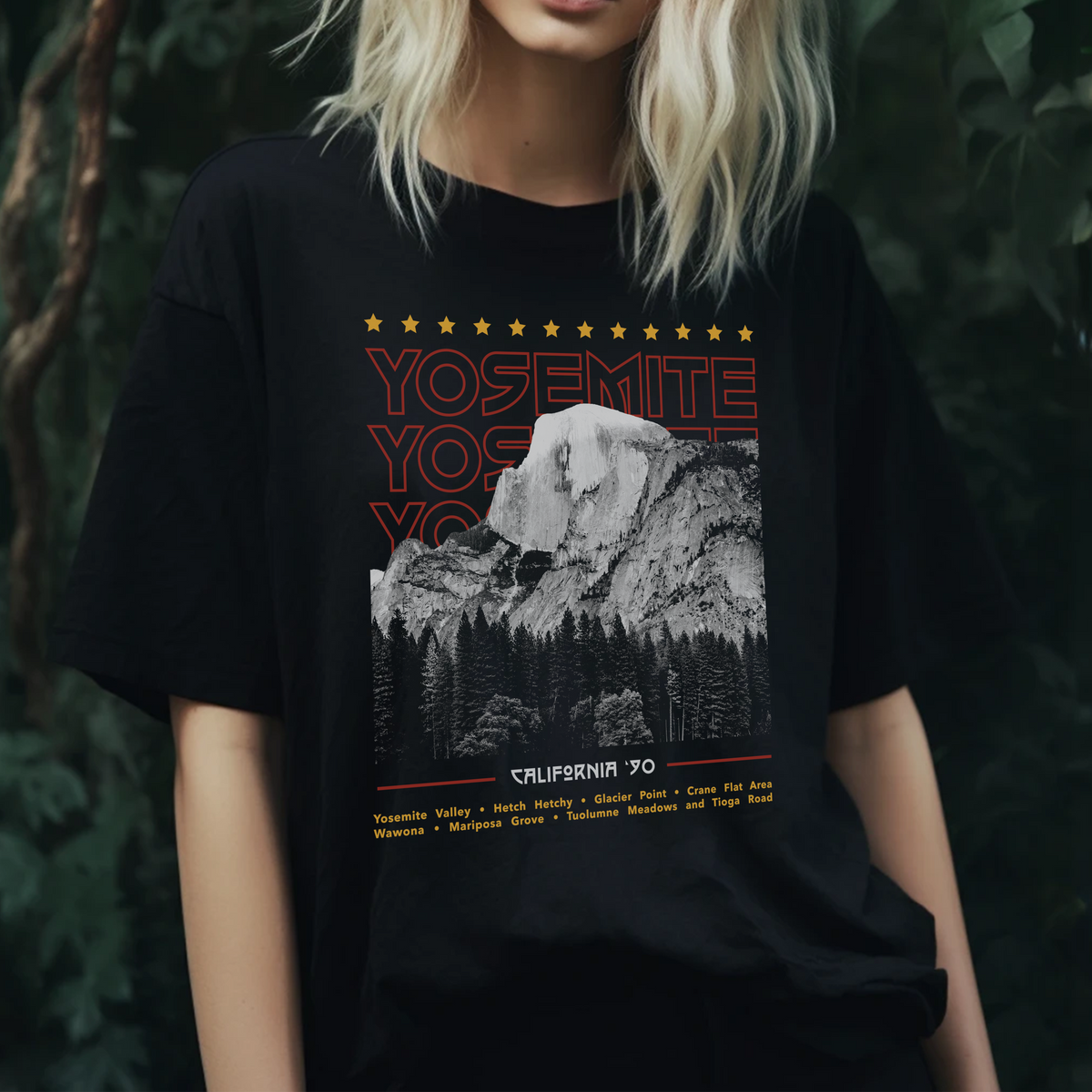 A woman wearing a black t-shirt with a 'Yosemite' graphic design, in front of a dark background